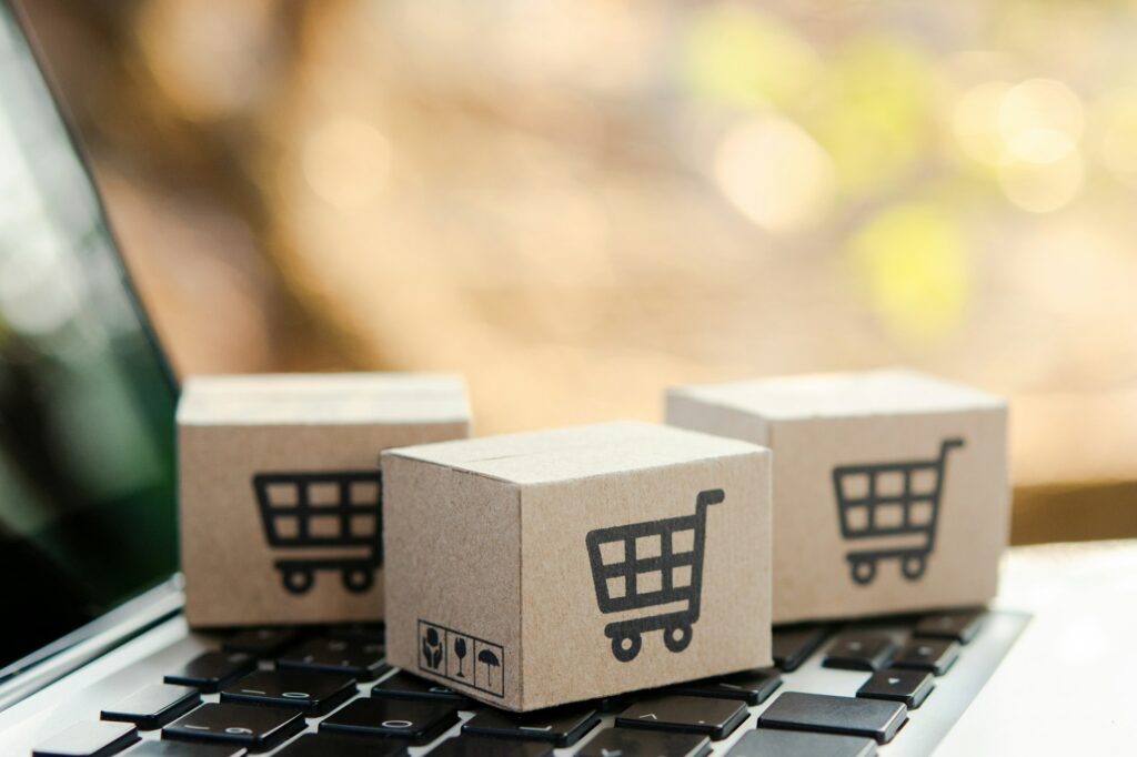 Cardboard box with a shopping cart logo on laptop keyboard.