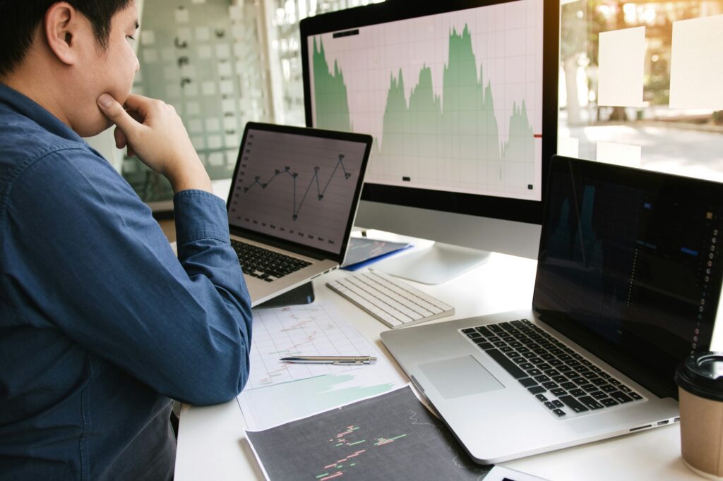 Investors are using laptops entering investment websites stocks market and partners