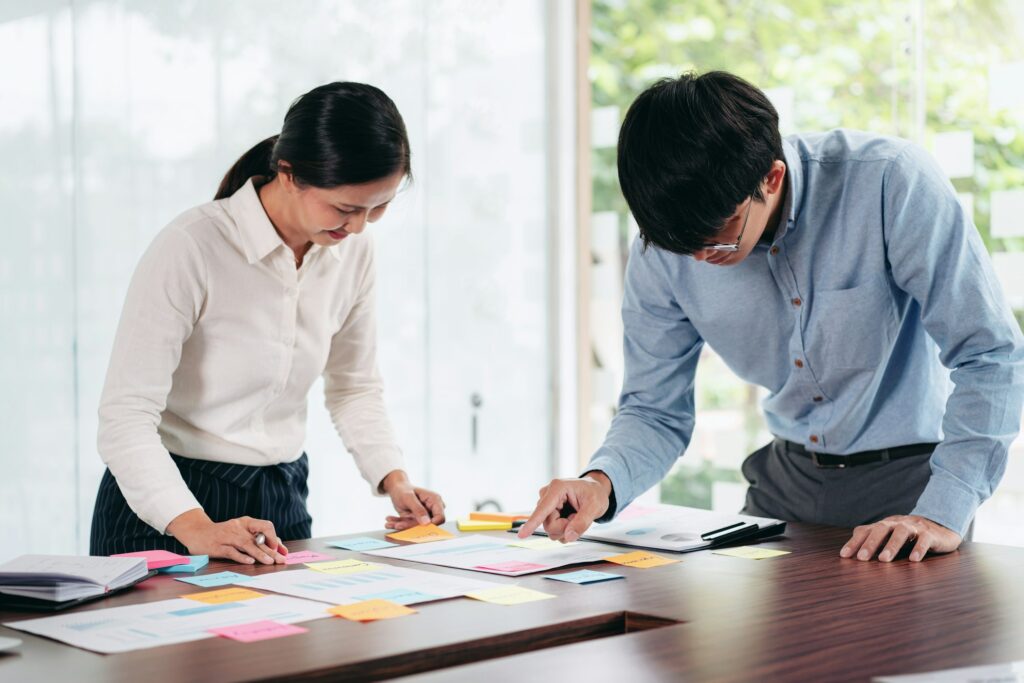 Business executive team brainstorm and takes notes on keyword ab