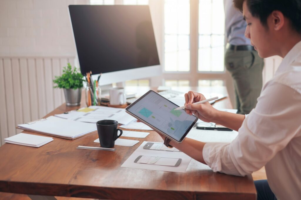 Designer man drawing a website outline and website ux app development on mobile phone.