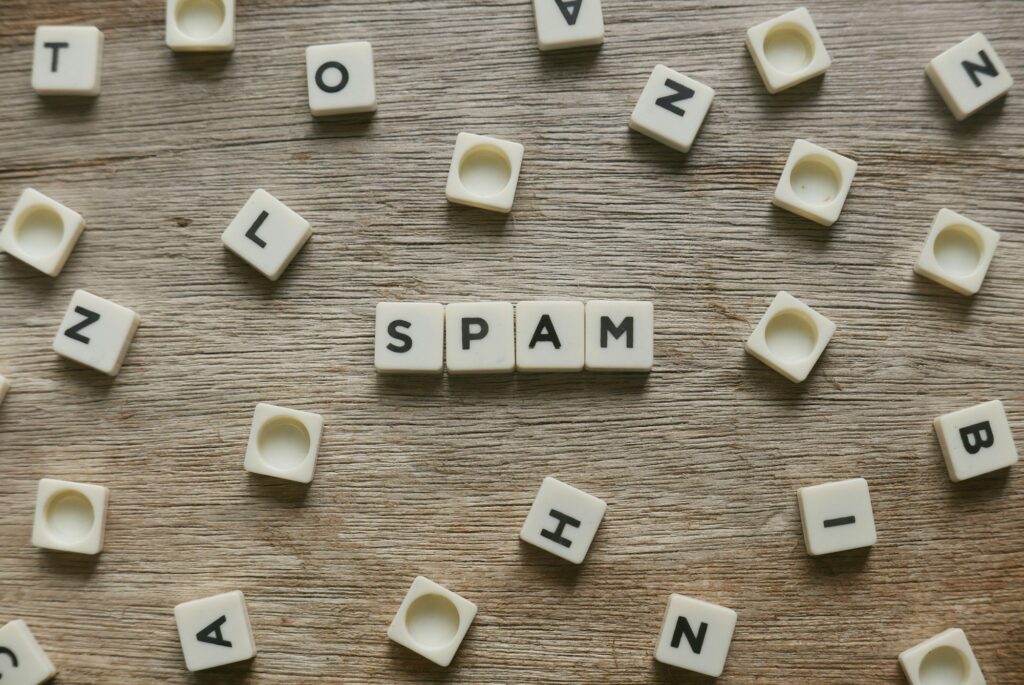 Spam word made of square letter word on wooden background. preventing spam on WordPress comments